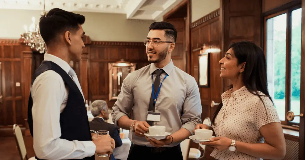 print on demand success - A group of people networking and discussing in a formal dining room.