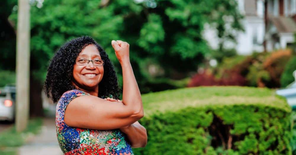 A lady shows the stay positive sign