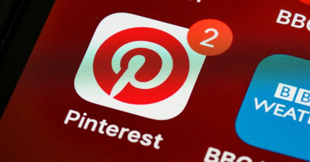 The pinterest logo is displayed on a cell phone for online store promotion ideas.